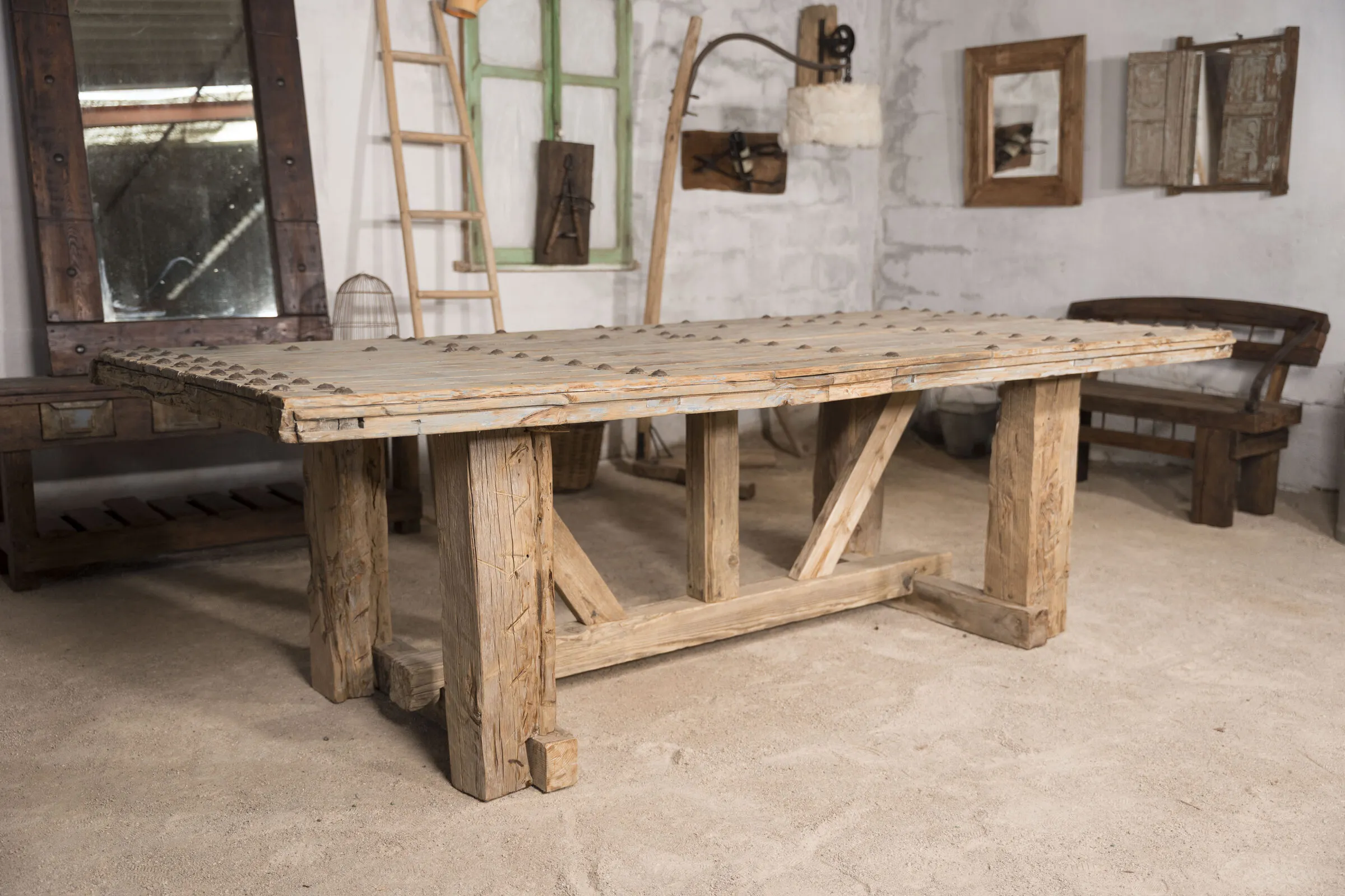 Mesa de comedor de madera recuperada con tablero claveteado, en el taller encalado
