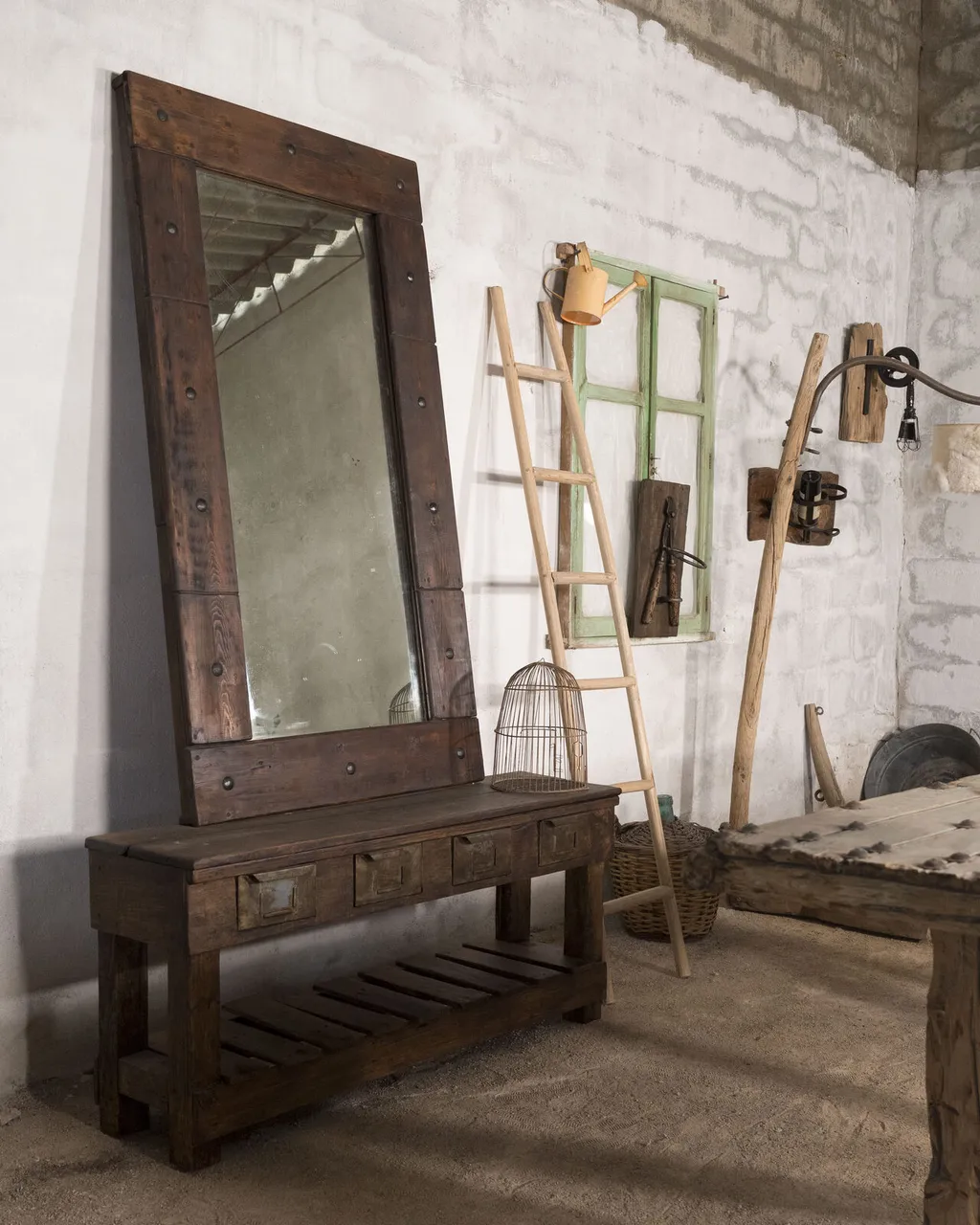 Tocador de madera oscura con espejo alto de marco claveteado y cajones, en el taller